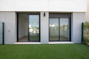 Fototapeta premium Ground floor apartment with sliding glass doors and private artificial grass garden