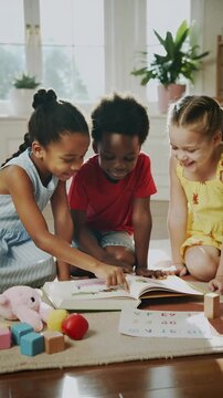 Young children reading a book together, vertical shot
