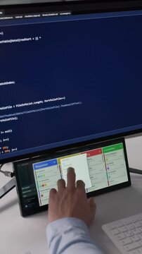 Agile Developer Checking Kanban Board On Secondary Screen While Writing Code