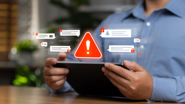 Cybersecurity breach alerts display a red warning symbol and an image of a business person typing on a laptop, indicating an email scam. This is to ensure technological security and prevent online att