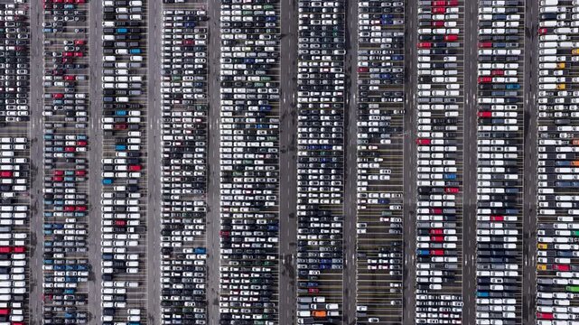 Aerial view of tightly packed cars in neat rows, creating a vibrant mosaic of colors and patterns, showcasing logistical precision, Trieste, Friuli-Venezia Giulia, Italy.