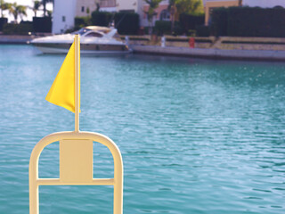 Yellow Flag At Quiet Marina By Water