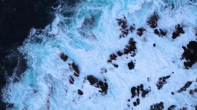Waves crashing on Tenerife beach aerial view. Waves crashing on a beach along the coastline. Coast with crystal-clear water.