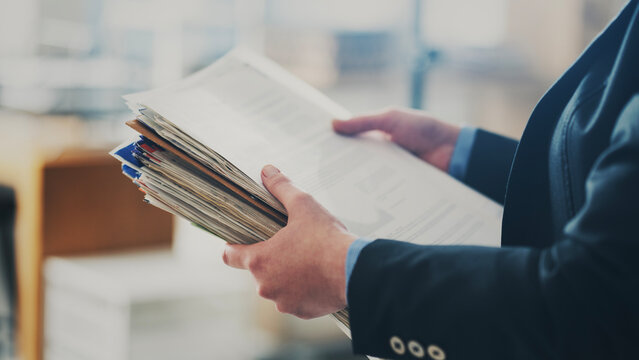Business person is holding a stack of papers
