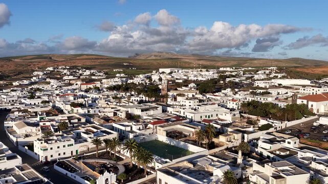 Aerial view of the beautiful white cityscape, contrasting with the arid landscape, a blend of urban and natural beauty, Teguise, Canary Islands, Spain.