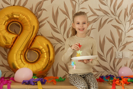 Happy Little Girl Taking Photo Next to Golden Number Eight Balloon After Birthday Party &ndash; Birthday Celebration Concept