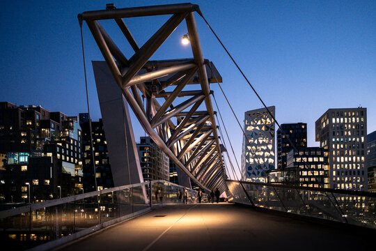 Night skyline meets modern architecture as bridge structure spans urban Oslo Barcode area Norway creating corporate infrastructure landmark view