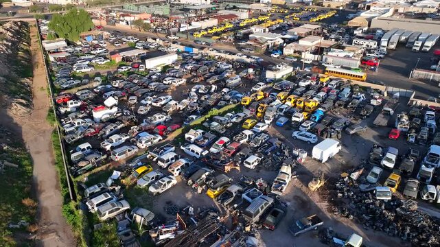 Aerial view of a sprawling auto salvage yard filled with closely packed vehicles, showing a mix of colors and textures, Phoenix, Arizona, United States.