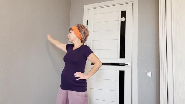 Senior woman sixty years old making side body stretch raising arm above head.