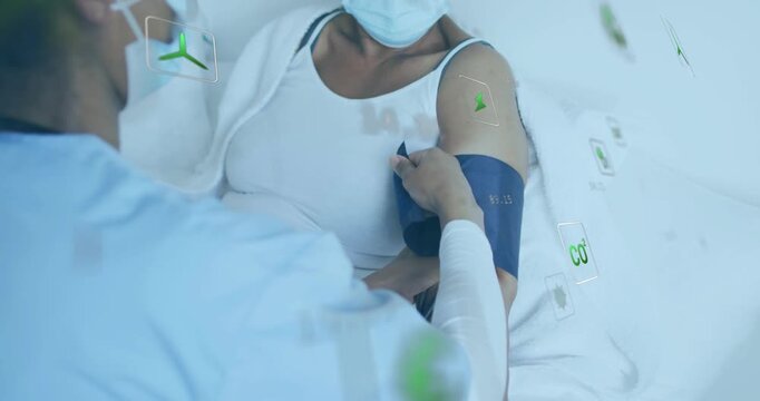 Caregiver bringing navy cuff, securing patient arm for BP monitoring with floating green icons