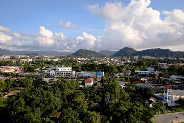 Obraz premium Scenic Cityscape With Hills and Lush Greenery Under a Blue Summer Sky