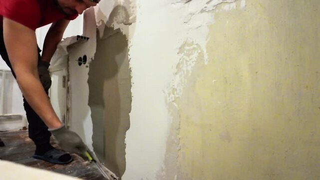 Handyman Restoring Wall With Plaster, Worker Applying Plaster Patch To Wall Opening Carefully, Meticulous Handyman Carefully Pressing Plaster Into Wall Opening With Safety Gloves And Steady Grip