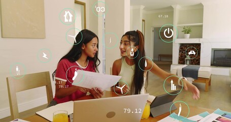 Naklejka premium Reviewing charts, pair in red tee, green top using laptop, tablet, AR overlays at home