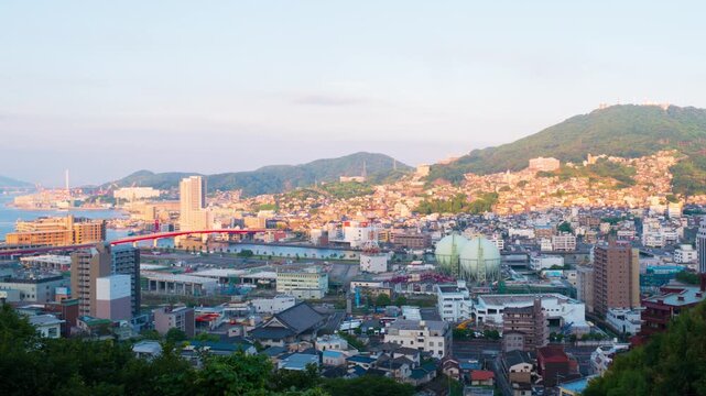 Nagasaki, Japan. Aerial timelapse made from a hill in Nagasaki, Japan, with a view over the entire center, including the bay and the hills. Cloudy and sunny day in summer, zoom in