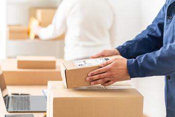 Male warehouse worker or seller packing ecommerce shipping order box for dispatching, preparing post courier delivery package, dropshipping shipment service concept.