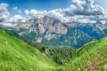 Marmolada mountain range towering over green valley, Dolomites, Italy