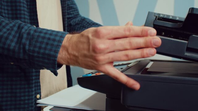 Man copying documents at office printer during a workday in a modern office setting