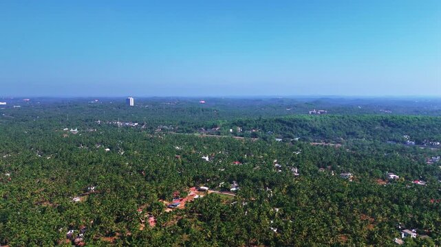 Aerial drone shot of a beautiful village in Kannur, surrounded by lush greenery, coconut trees, and calm rural landscapes.