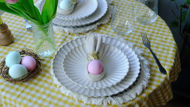 Easter table setting with tulips and Easter eggs. Spring table decoration. Holiday dinner. 