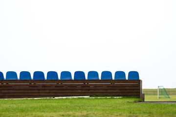 Rows of seats at a football pitch in foggy weather

