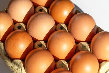 A full 12-count carton of eggs shot from an angle, showing the depth of the cardboard packaging © Katerina