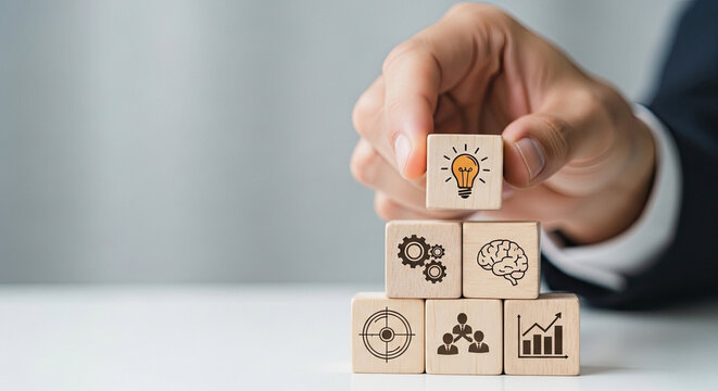Hand arranging wooden blocks with icons representing business strategy and innovation concepts