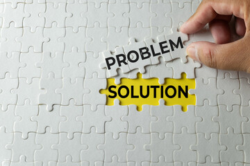Business problem solving and finding solution concept. Hand lifting jigsaw puzzle piece to show hidden text. Metaphor of overcoming challenge, strategy, and smart analysis.
