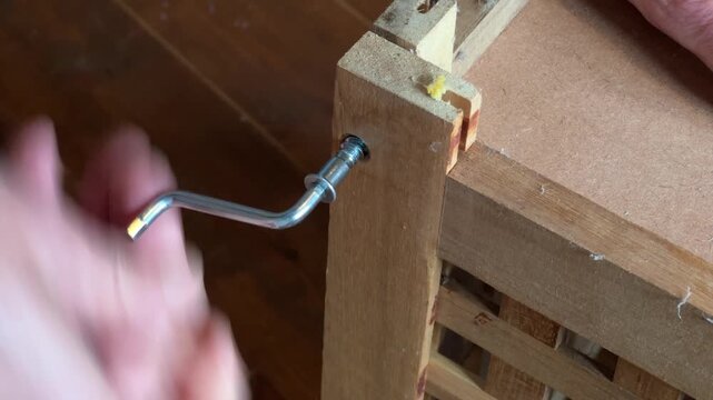 Unsrewing taking apart a flat-pack table