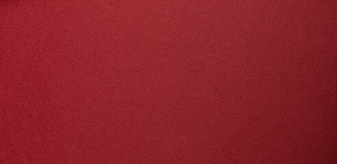 deep red textured background with flat surface. Fine woven grain and matte tactile material create a
