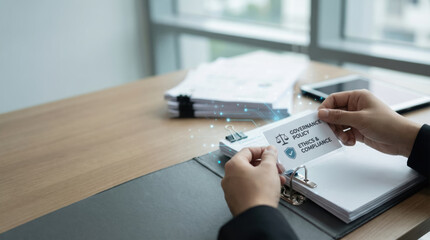 Governance policy ethics compliance card held by person with documents and tablet on wooden desk symbolizing ai investment loss risk
