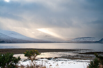 Fototapeta premium Winter Coastal Landscape with Snowy Hills and Calm Water