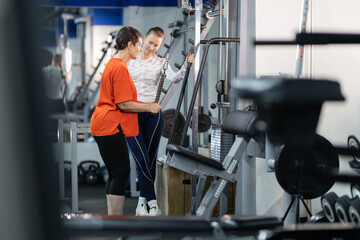 Personal trainer guiding woman during gym workout
