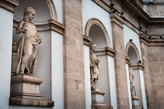 landscape shot of three bronze statues in Vienna city centre during winter in December with warm light on the sculptures