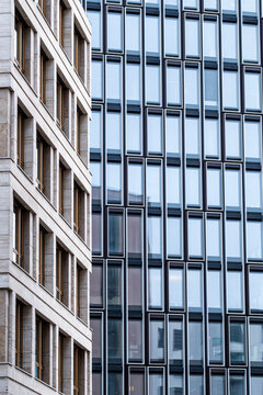 Modern glass office building facade with windows in urban architecture pattern showing vertical design details for corporate exterior