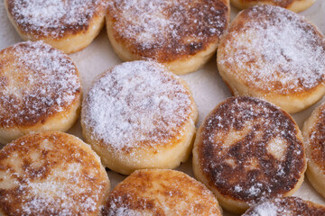 Holiday themed breakfast display, Warmly decorated seasonal brunch arrangement, Charming holiday breakfast featuring golden syrniki with sprinkled sugar and warm tones