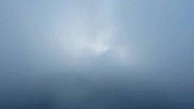 Pastel Whispering Mist A static, loopable shot of a dreamlike environment, where delicate tendrils of pastel blue-grey mist subtly ebb and flow. The monotone color scheme enhances the atmospheric