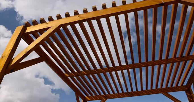 a wooden frame made of logs and planks on the beach , part of a wooden frame building under construction on the beach to create a good infrastructure for recreation, a canopy made of planks