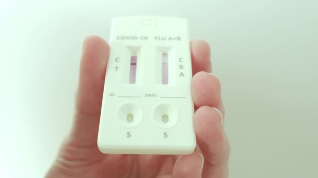 Narva, Estonia &ndash; February 6, 2026: Close-up of a person adding liquid solution to a rapid antigen test cassette as test lines begin to appear. Real home testing process. Editorial use only.
