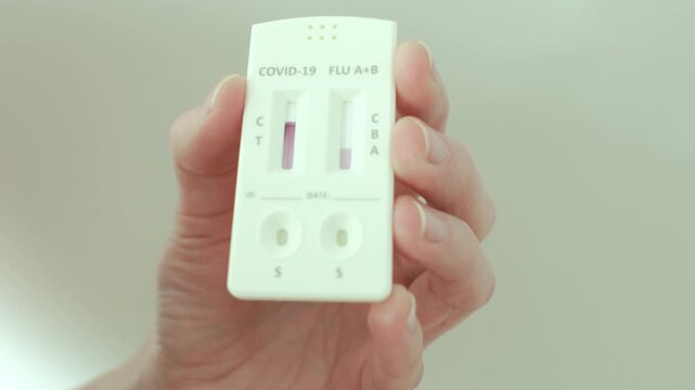 Narva, Estonia &ndash; February 6, 2026: Close-up of a person adding liquid solution to a rapid antigen test cassette as test lines begin to appear. Real home testing process. Editorial use only.
