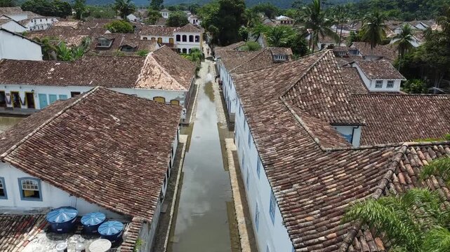 Aerial shot following a flooded street in Paraty, Brazil, made to cleanse the town in colonial times. Flooding occurs at high tide during full and new moon, blending history with unique visuals