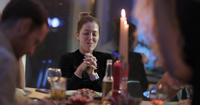 Friends and Family Enjoy a Delicious Meal and Lively Conversation by Candlelight