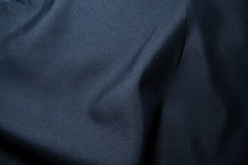 Dark blue cloth background with subtle textile wrinkles