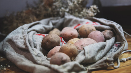 worek ziemniaków z suszonymi kwiatami w tle © Katarzyna