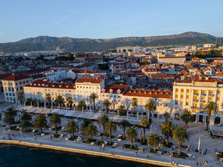 Aerial view of Split Riva promenade with historic facades, cafes and palm trees along the Adriatic Sea, Croatia