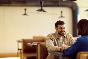 Obraz premium Friendly Business Meeting Over Coffee in a Modern Diner Setting With a Smiling Man