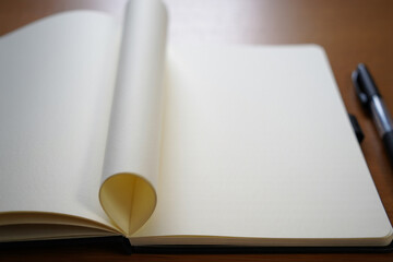 open notebook with rolled page and pen on wooden desk, for mockup or template, isolated on transparent background, png