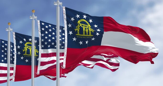 Flags of Georgia and United States waving in the wind on a clear day