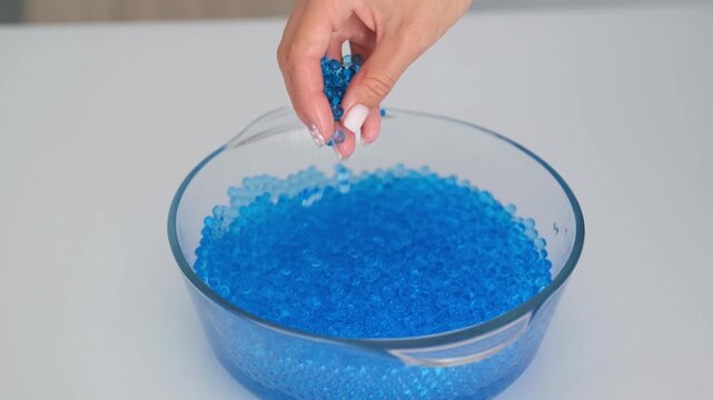 Women's hands playing with blue orbeez balls