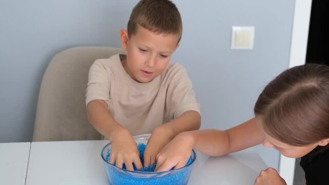 Children play with blue orbeez balls.