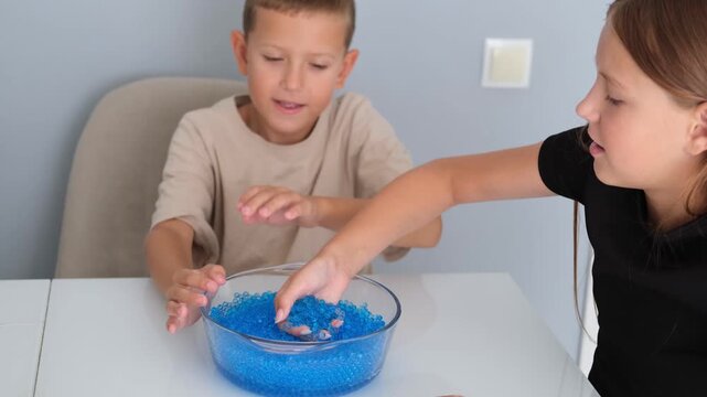 Children play with blue orbeez balls.